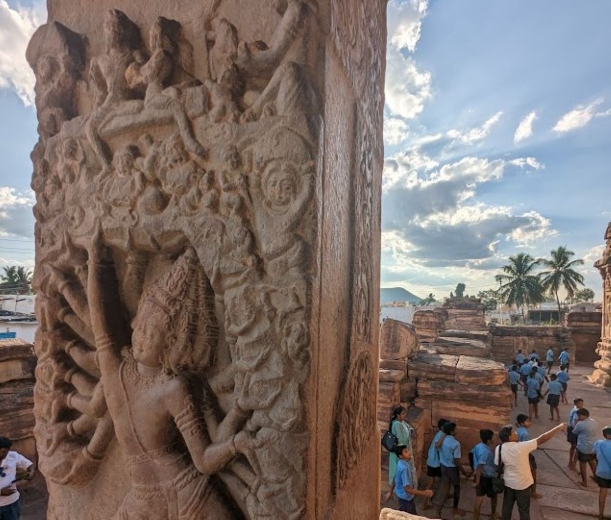 School students at Karnataka's Pattadakkal, a UNESCO world heritage site. The sculpture is of Ravana lifting Kailasa, Virupaksha temple, Pattadakkal