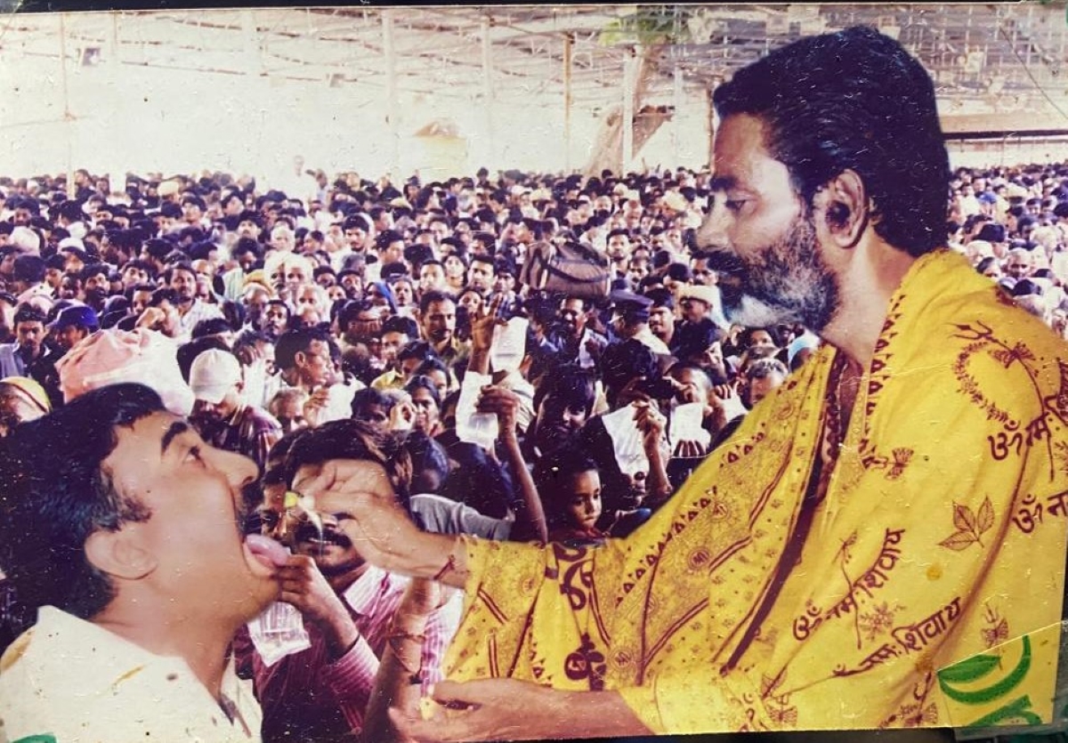 Bathini Harinath Goud feeding the prasadam to a patient. (Supplied)