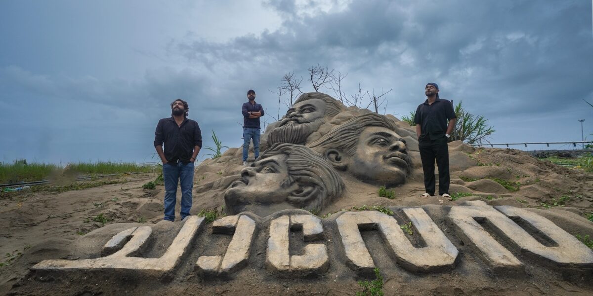 Chaaver actors in front of sand replica