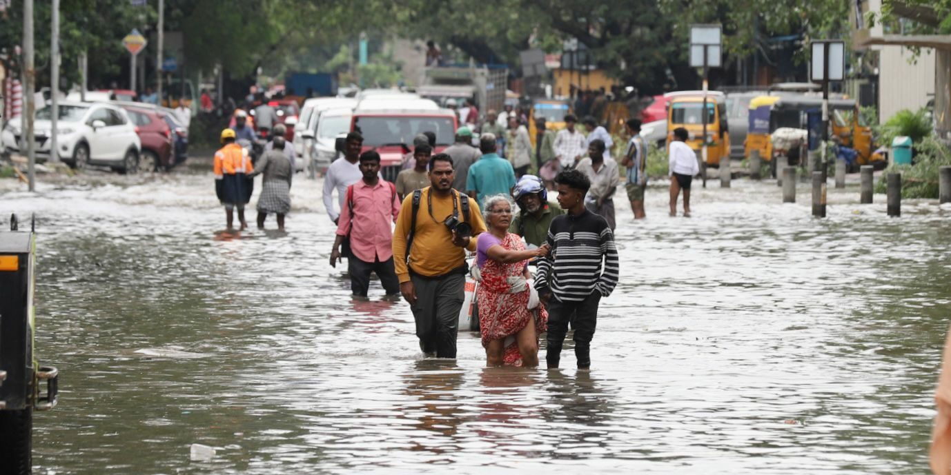 Chennai residents struggling through a waterlogged road.