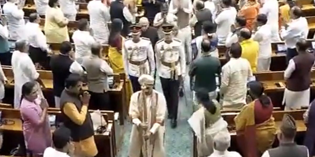 President Droupadi Murmu being escort by a guard carrying the Sengol.