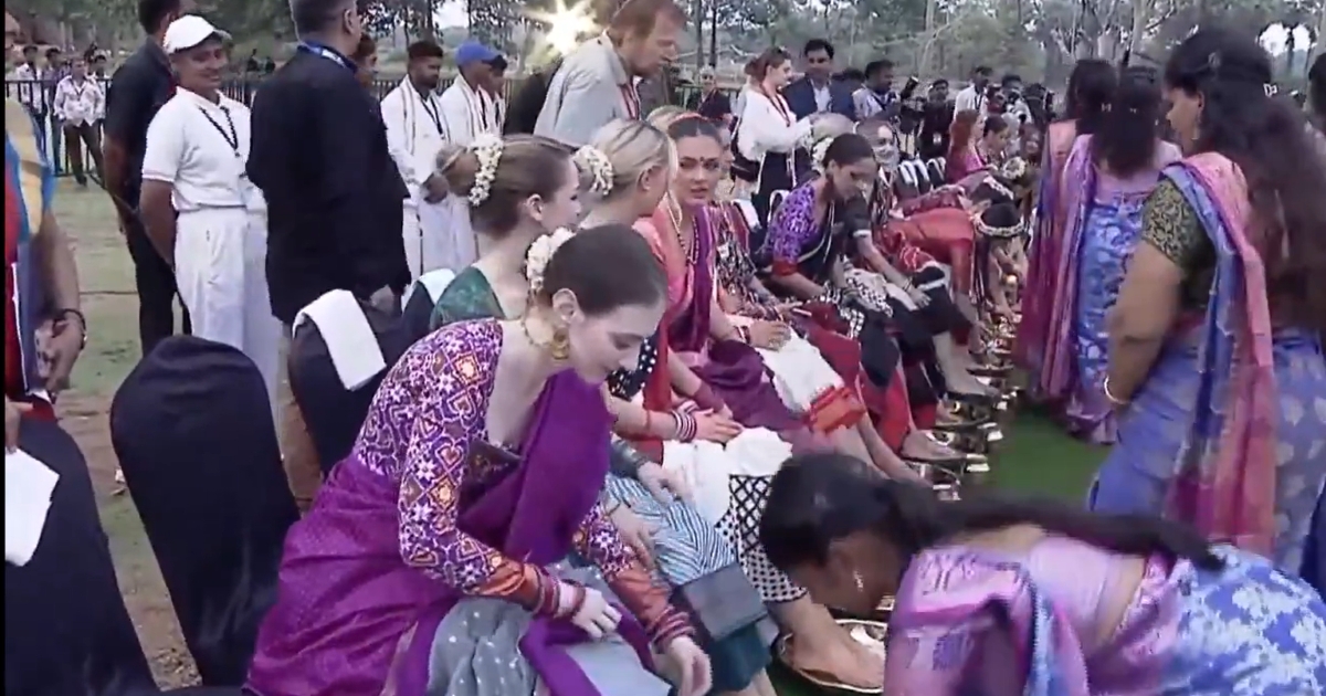 Woman volunteer washing the feet of Miss World contestant